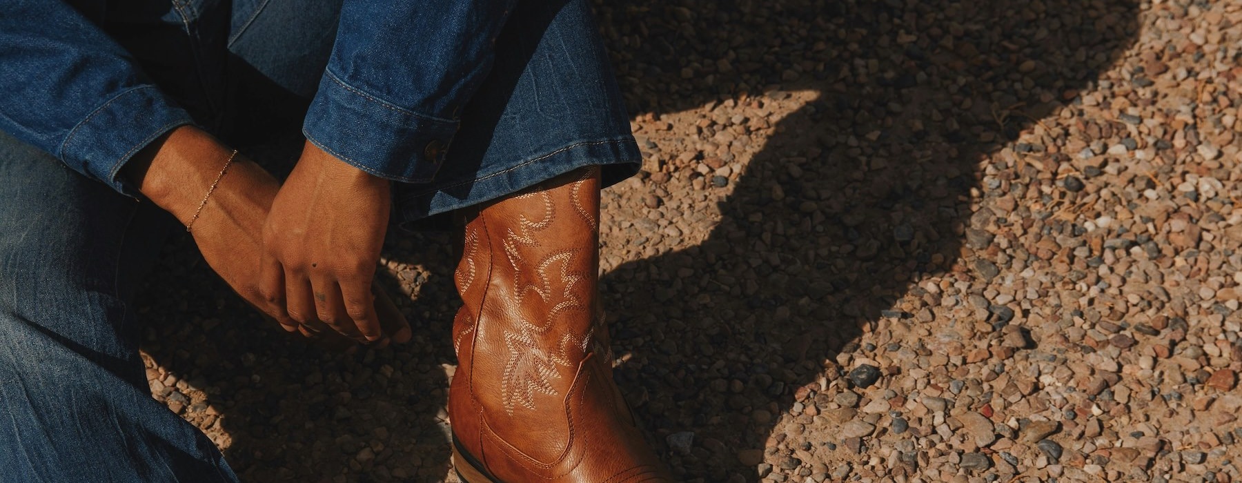 a man wearing a denim jacket and brown boots